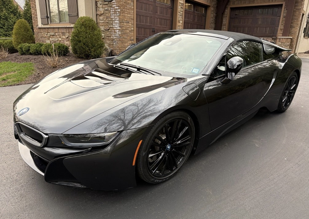 Black BMW i8 coupe in a driveway before Allstar Hauling transport