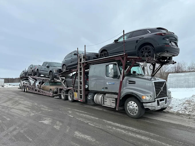 Allstar Hauling Volvo car hauler loaded with SUVs and a classic car during an upstate New York winter