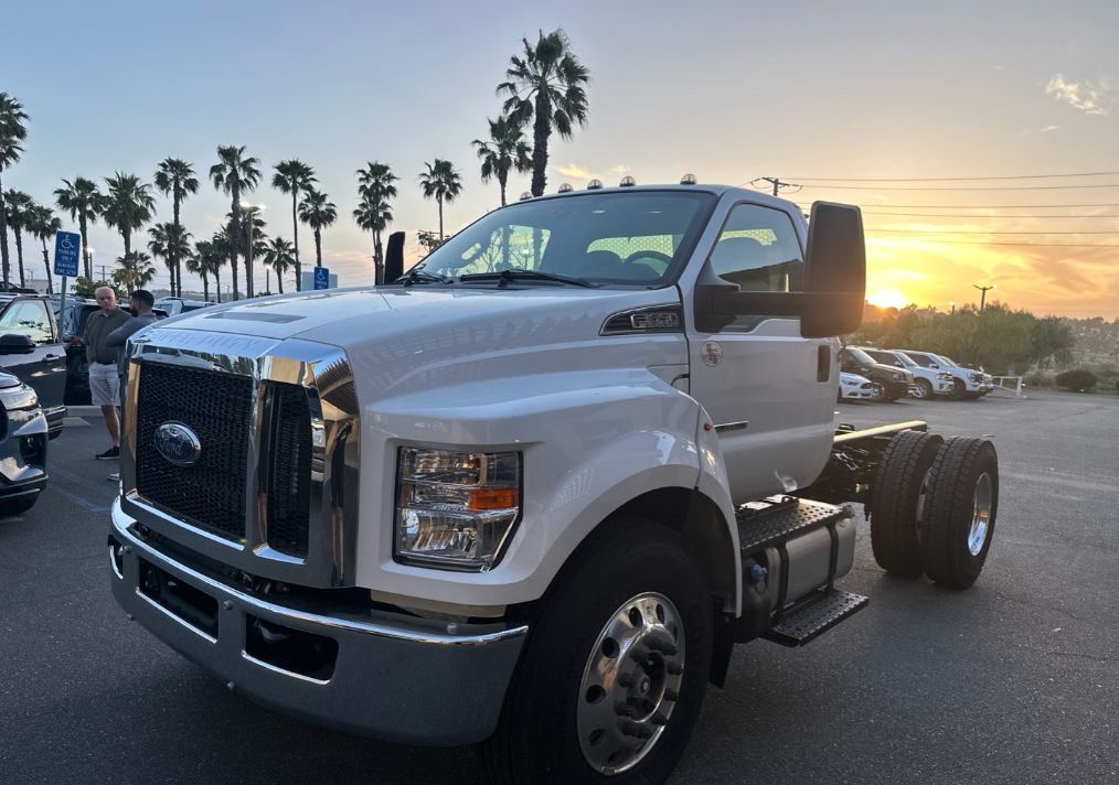 White Ford F-650 cab and chassis truck at sunset before Allstar Hauling transport