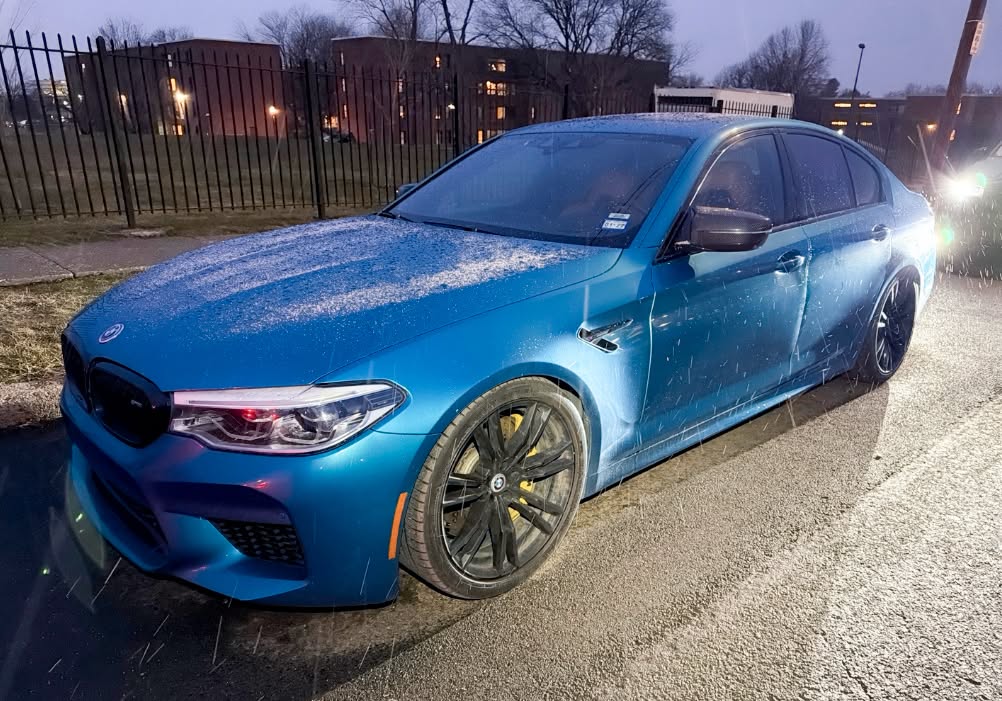 Blue BMW M5 Competition sedan in the snow before Allstar Hauling transport