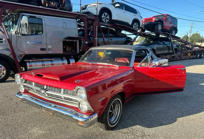 Red 1966 Mercury Comet Cyclone convertible beside an Allstar Hauling carrier