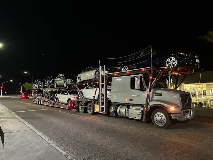 Allstar Hauling nine-car Volvo carrier fully loaded at night on a dealership lot