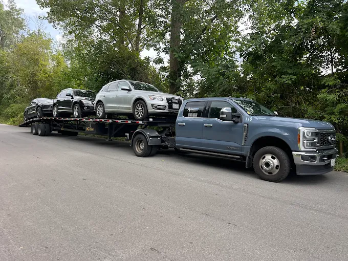 Allstar Hauling Ford F-350 dually with a three-car wedge trailer loaded with an Audi Q5 and sedans