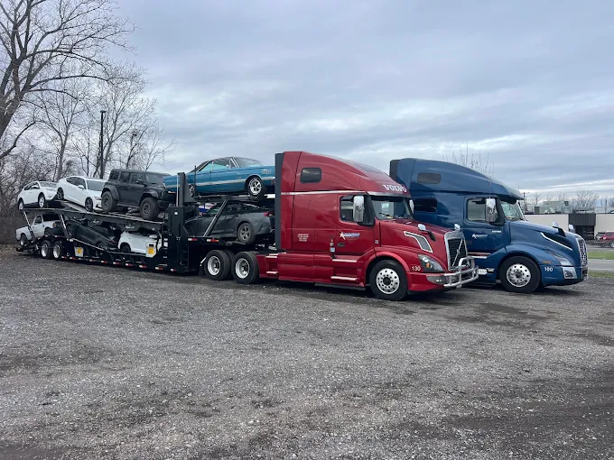 Red and blue Allstar Hauling Volvo car carriers parked side by side at the West Henrietta, NY yard