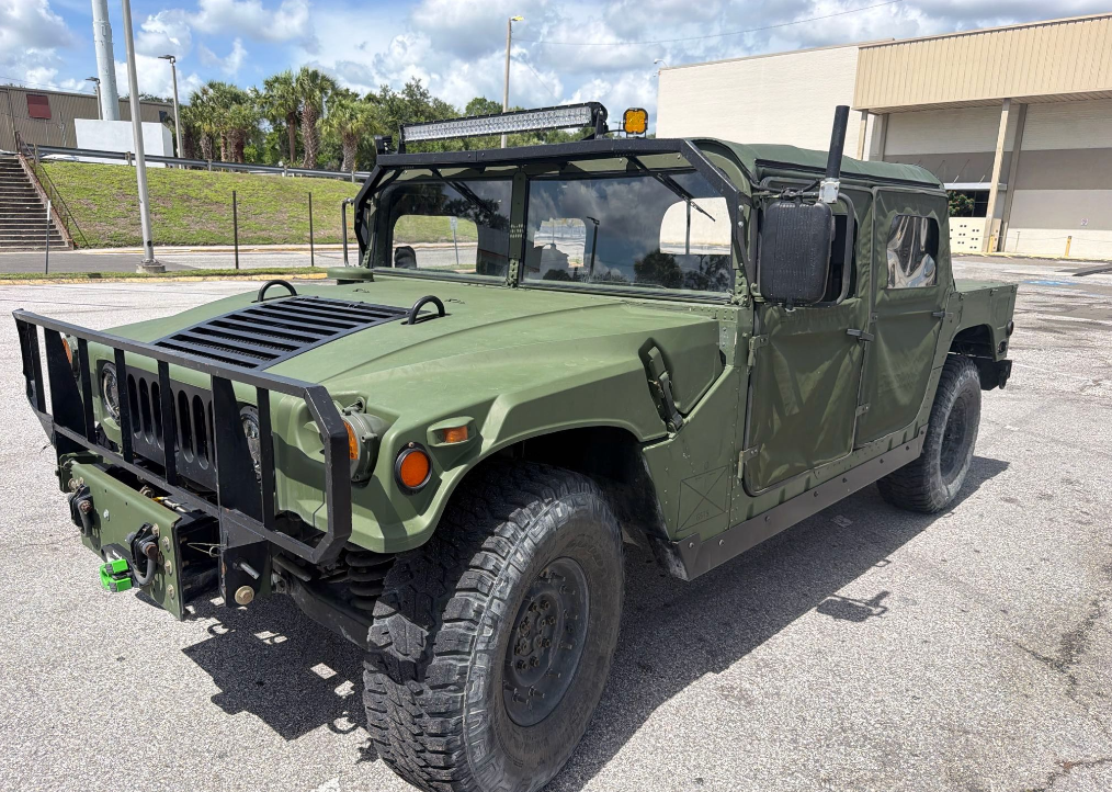 Olive green AM General HMMWV Humvee transported by Allstar Hauling
