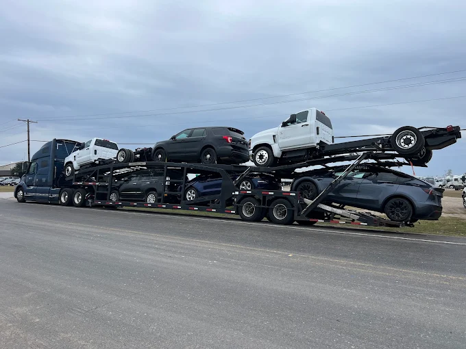 Heavy-duty trucks and a Tesla loaded on an Allstar Hauling carrier
